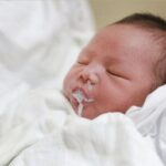 Beba bljucka nakon podoja dok je majka drži uspravno