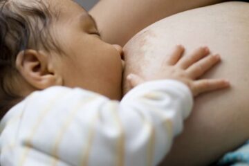 Majka s većim dojkama doji bebu uz pravilnu podršku dojke i položaj tijela
